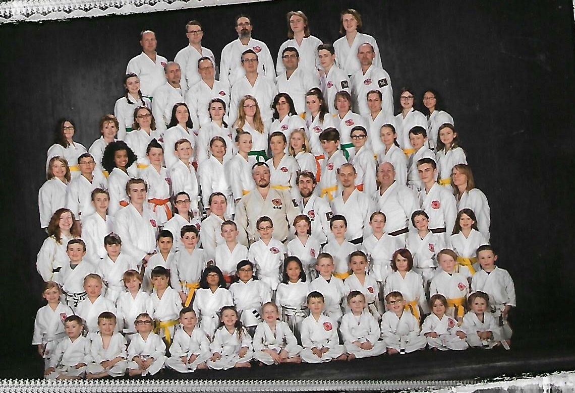 An archival Yobukan community photograph of karate students of different ages and belt levels
